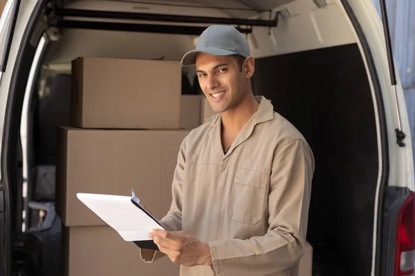 Happy Delivery Man Looking Camera While Writing Clipboard Van Warehouse — Stock Photo, Image