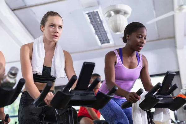 Front View Diverse Fit Women Exercising Exercise Bike Fitness Center — Stockfoto