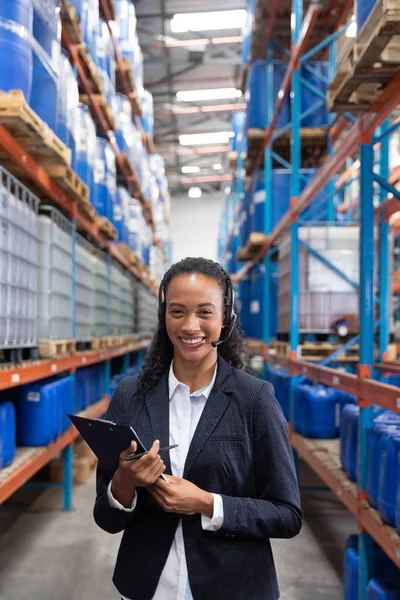 Portret Van Vrouwelijke Manager Praten Headset Terwijl Klembord Magazijn — Stockfoto