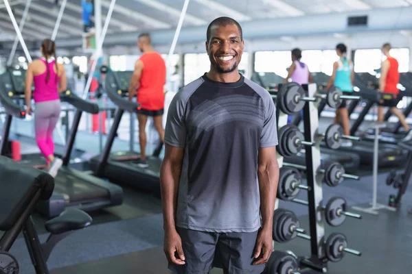 一个快乐的非裔美国人站在健身中心看着相机的画像 健康的人锻炼身体和训练的明亮的现代体育馆 — 图库照片