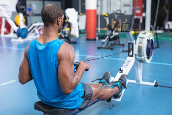 Achteraanzicht Van Afro Amerikaanse Fitnessman Die Het Fitnesscentrum Een Roeimachine — Stockfoto