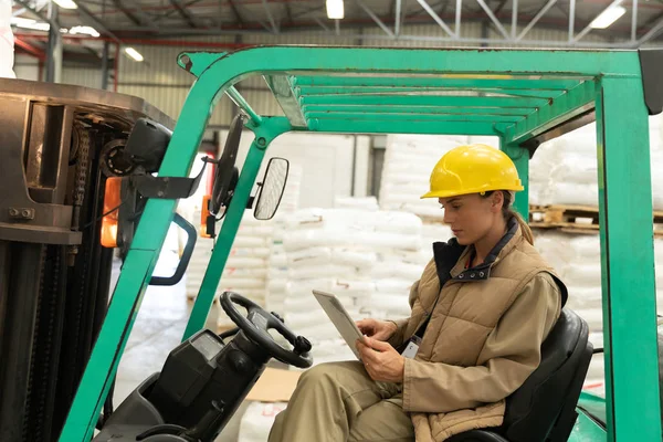 Side View Female Worker Using Digital Tablet While Sitting Forklift — Stock Photo, Image