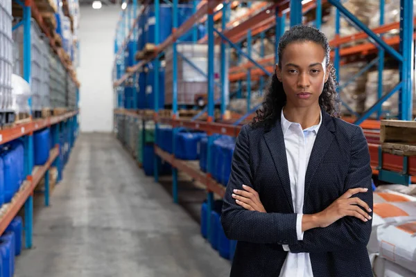 倉庫で腕を組んで立っている女性マネージャーの肖像 — ストック写真