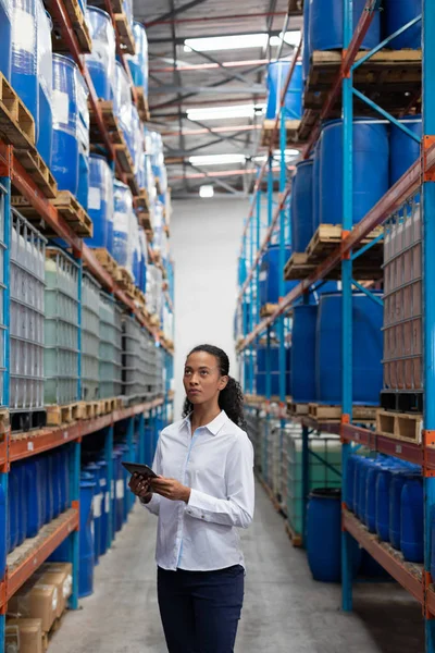 倉庫の在庫を確認しながらデジタルタブレットを使用してアフリカ系アメリカ人の女性マネージャー — ストック写真