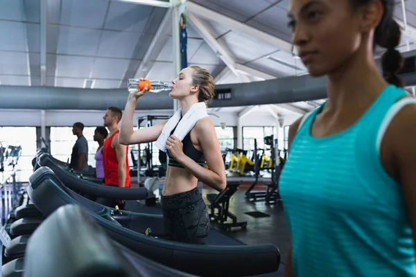 Side View Caucasian Fit Woman Drinking Water While Exercising Treadmill — Stockfoto