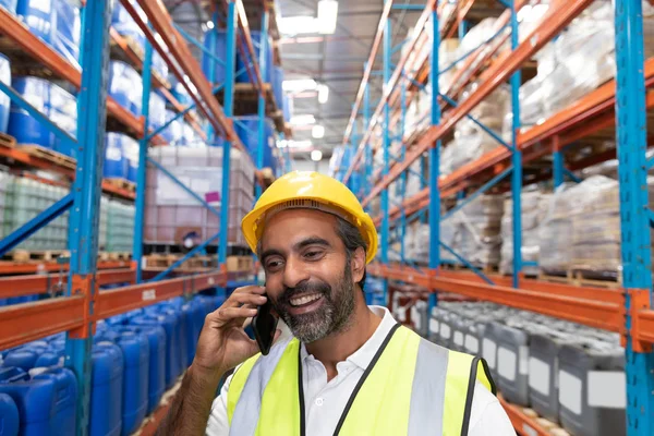창고에서 전화로 이야기하는 행복한 노동자 — 스톡 사진