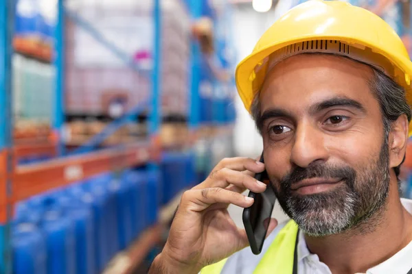 倉庫で携帯電話で話す男性作業員のクローズアップ — ストック写真