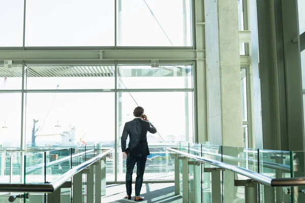 Achteraanzicht Van Zakenman Praten Mobiele Telefoon Gang Bij Modern Kantoorgebouw — Stockfoto