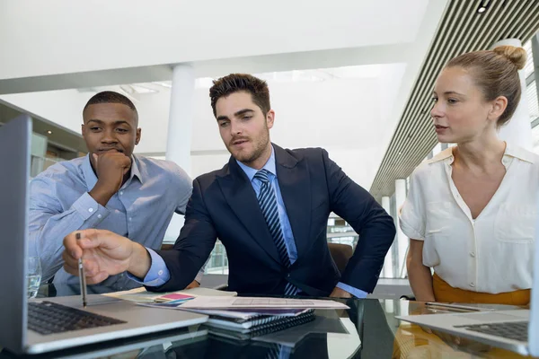 アフリカ系アメリカ人の若いビジネスマンと若い白人ビジネスマンとビジネスマンが一緒に現代のオフィスの机に座って働く正面図 — ストック写真