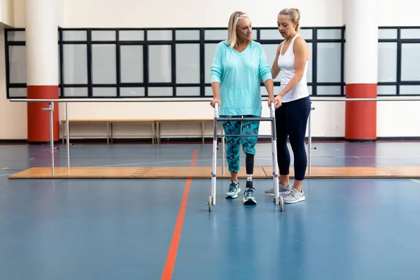 Physiotherapeutin Hilft Gehbehinderter Seniorin Mit Rollator Sportzentrum — Stockfoto