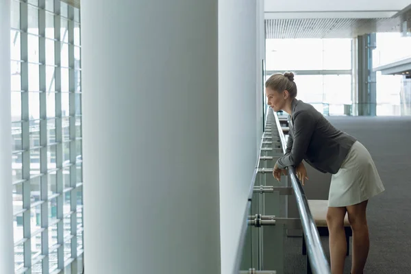 Nachdenkliche Geschäftsfrau Lehnt Büroflur Geländer — Stockfoto