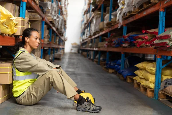Tired Female Staff Sitting Floor Warehouse — Stockfoto