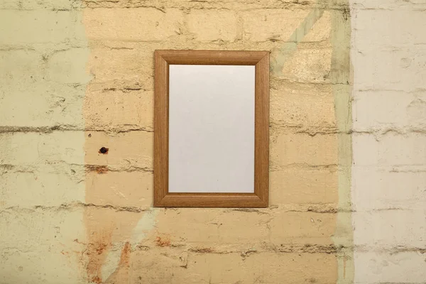 黄色いレンガの壁に掛かっているフレームの空白の絵のクローズアップ — ストック写真