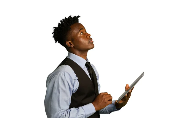 タブレットコンピュータを持っているベストとネクタイを身に着けている若いアフリカ系アメリカ人のビジネスマンの側面図 — ストック写真