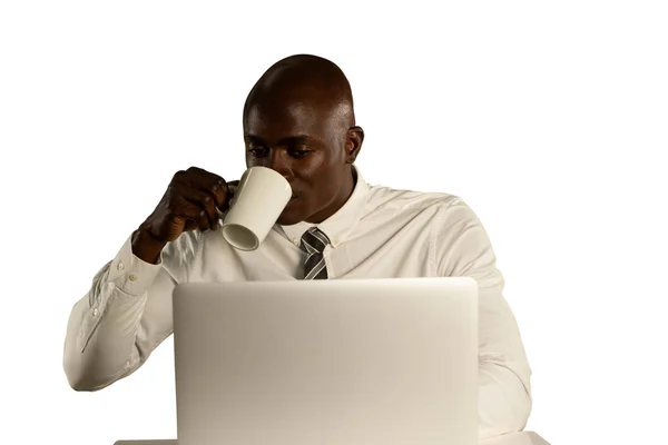フロントビューの近くにはげ若いアフリカ系アメリカ人ビジネスマンのシャツとネクタイを着てラップトップを使用して座ってコーヒーを飲んで — ストック写真