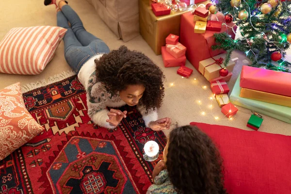 크리스마스에 자신의 거실에서 그녀의 여자의 전면보기 중간에 스노우 글로브와 바닥에 — 스톡 사진