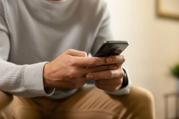 Вид Спереди Средней Части Человека Использующего Смартфон Сидящего Своей Гостиной — стоковое фото