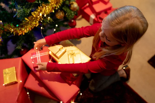 クリスマスの時に彼女の居間でプレゼントを包む若い白人の女の子の頭上の眺め — ストック写真