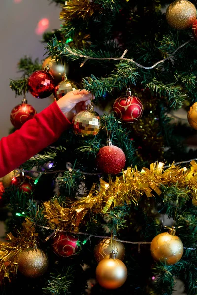 クリスマスの時期に居間にクリスマスツリーを飾る女の子の手 — ストック写真