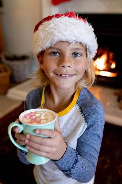 Noel Zamanı Oturma Odasında Bir Fincan Tutan Noel Baba Şapkası — Stok fotoğraf