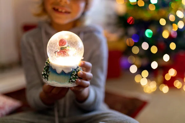 圣诞节时 一个快乐的白人小男孩坐在地板上 拿着雪球微笑着坐在客厅里 前视中段 — 图库照片