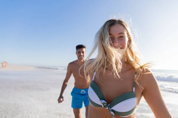 白人夫婦は晴れた日にビーチで時間を楽しみ 背景に海と手を取り合って歩く — ストック写真