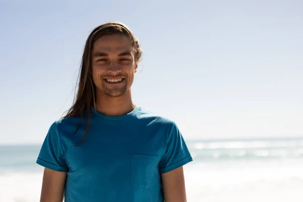 在阳光灿烂的日子里 一个白人男子在海滩上享受时光的画像 他看着相机 面带微笑 — 图库照片