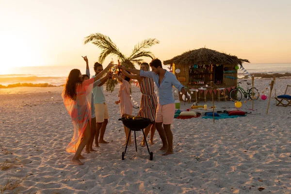 Grupo Multiétnico Amigos Disfrutando Tiempo Juntos Una Playa Atardecer Bebiendo —  Fotos de Stock