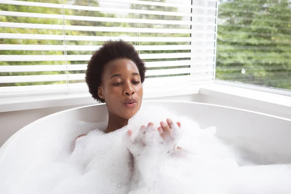 男女混血的女人在科罗纳韦病毒流行期间 在家中度过了自我隔离和社会隔离的时间 她们享受着泡沫般的 温暖的洗澡 吹风和快乐的样子 — 图库照片