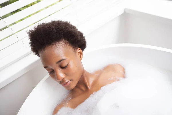 男女混血的女人在自己家里呆着 在科罗纳维病流行期间进行自我隔离和社会隔离 享受泡沫般的温暖浴和放松 — 图库照片