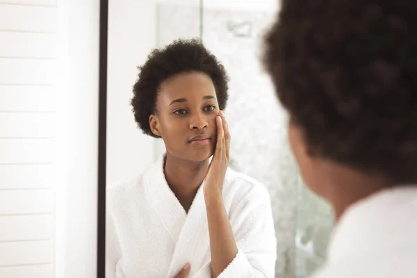 男女混血的女人在自己家里呆着 自我隔离 在科罗纳维病流行期间与外界保持距离 照顾她的皮肤 看着浴室里的镜子 — 图库照片