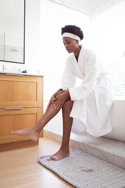 混合人種の女性過ごす時間に自宅で自己隔離と社会的距離で隔離されたロックダウン中にコロナウイルスCovid 19流行 彼女の足の皮膚の世話で彼女のバスルーム — ストック写真