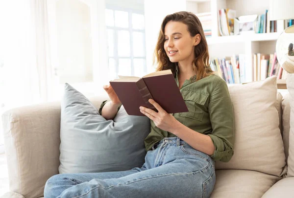 白人女性は家で時間を過ごし ソファに座り 本を読んでいる 家庭での生活隔離 コロナウイルスの間の隔離されたロックダウンの社会的距離は19パンデミックを克服 — ストック写真