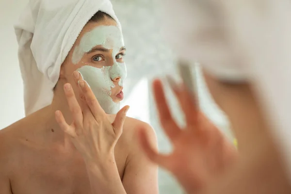 Beyaz Bir Kadın Evde Oturup Aynaya Bakıyor Yüz Maskesi Takıyor — Stok fotoğraf
