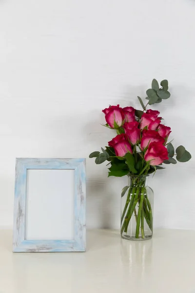 Zavřít Pohled Prázdný Rámeček Růžovými Růžemi Umístěnými Skleněné Váze Uspořádané — Stock fotografie