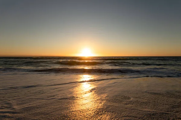 Вид Піщаний Пляж Спокійне Море Хвилями Блакитним Небом Заході Сонця — стокове фото