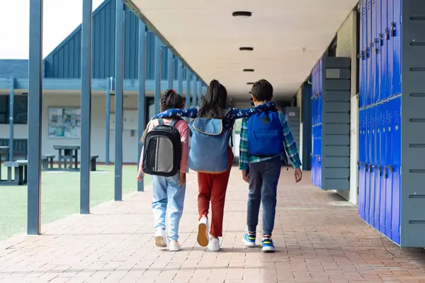 Three Children Walking School Corridor Arms Each Other Shoulders Biracial — Stock Photo, Image