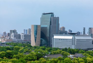 Duvar ve Osaka Kalesi ve Osaka Business Park gökdelenler arka plan üzerinde etrafında hendek. Osaka Kalesi Japonya'nın en ünlü simge ve simge Osaka City biridir. Bahar zamanı, güneşli bir gün.