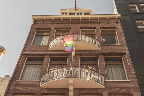 A rainbow flag (LGBT movement) seen from the ground up flutters — Stock Photo, Image