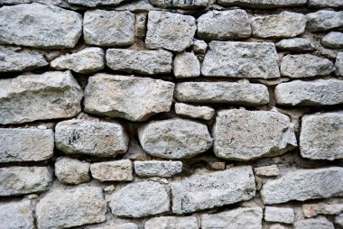 Gri kayrak duvar taş arka plan veya doku. Işık pürüzlülüğü kayrak ve ufalanan yapı malzemesi ile yüzey.