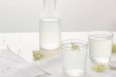 Mürver çiçekli limonata. İçme bardağındaki yaz kokteylini tazeliyorum. Yatay oryantasyon. Seçici odak.