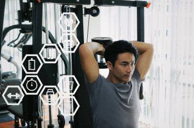 Asya genç yakışıklı adam triceps grafik simge diyagramı, vücut geliştirmeci, sağlıklı yaşam, egzersiz ve spor eğitim kavramı ile fitness salonunda iyi vücut için dumbbell ile egzersiz yaparak