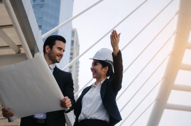 Grup iş ya da mühendis kadın ve yeni proje, başarılı konsepti başlangıç planlama adam kask ve binaya planlama ve modern şehir, çalışmalarını kontrol planı