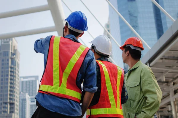 エンジニア 技術者や建築家建築の近代的な都市建設の背景 建設現場 産業と労働者の概念設計と計画に関する計画安全ヘルメットの背面図グループ — ストック写真