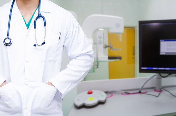 handsome man, smart doctor with stethoscope around his neck with Mammography X-Ray System Machine in hospital background, cancer and disease treatment, health care and medical technology concept