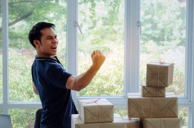 Başlamak yukarıya. genç adam yeni dizüstü bilgisayar, cep telefonu, teslim ambalaj kutusu tablo, evde çalışma office, KOBİ, küçük işletme sahibi ile müşteri online kavramı alışveriş siparişinden sonra mutlu