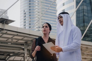 Mobil holding beyaz elbiseli Genç yakışıklı Arap iş adamı tablet ile sekreter Asyalı kadın modern şehir, finans, yatırım, takım çalışması, şirket başarı ve iş büyüme kavramı