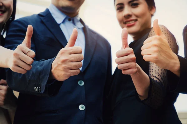 close up of hand group of young business people team in suit showing thumbs up as like sign together in the city, successful, support, meeting, partner, teamwork, community and connection concept