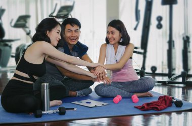 Genç spor insanlar takım onların hedefe ulaşmak ve yüksek beş birlikte yoga mat fitness salonunda oturuyor yapıyor egzersiz planlama, eğitim, egzersiz, ortaklık, başarı ve ekip çalışması kavramı