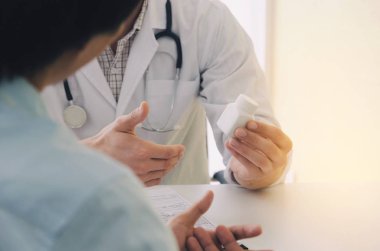 Genç bir doktor veya eczacı ile tutarak veya ilaç şişesi elinde hasta hastane, sağlık, tıp, eczacılık ve sigorta kavramı içinde gösterilen stetoskop